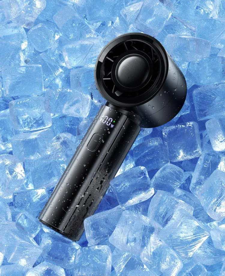 The black coldSky handheld turbo fan lying on ice cubes with its digital display lit